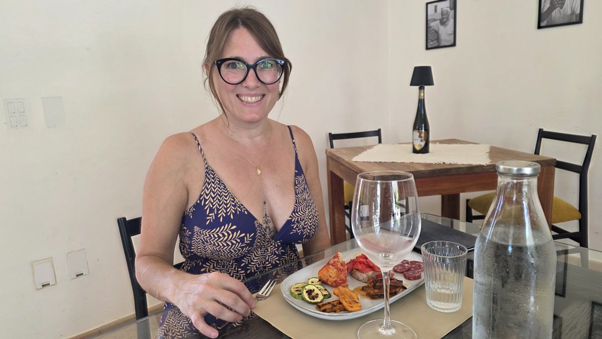 Jenn at the tasting table, with a plate of food alongside the wine glasses.