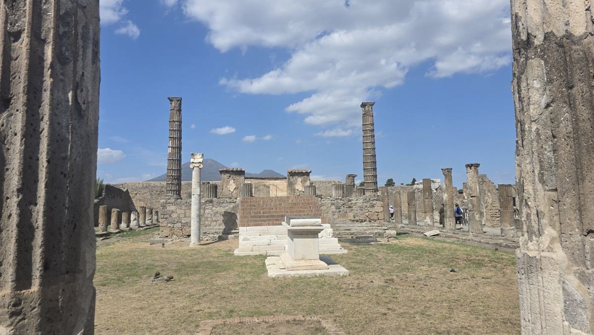 Columns and ancient walls beneath a blue sky at Pompeii.