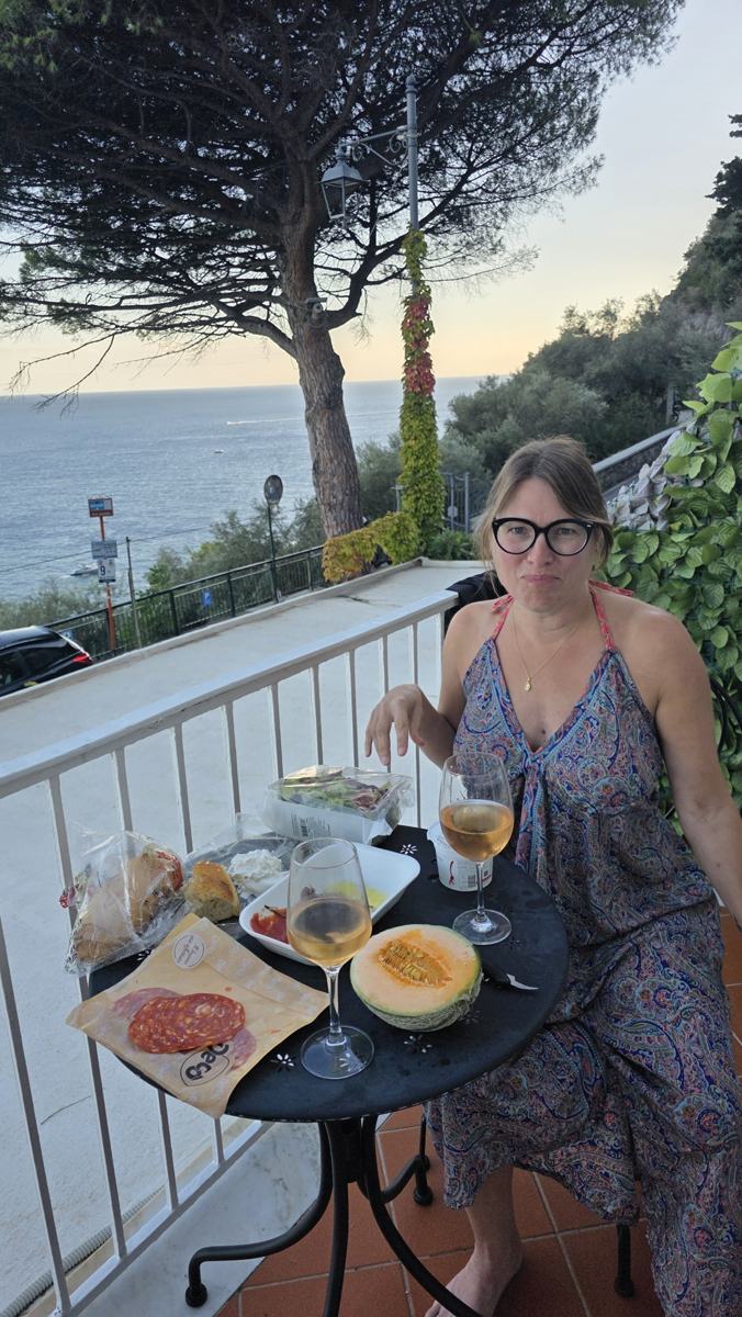 A simple balcony meal: cheese, cured meat, melon and wine with a sea view.