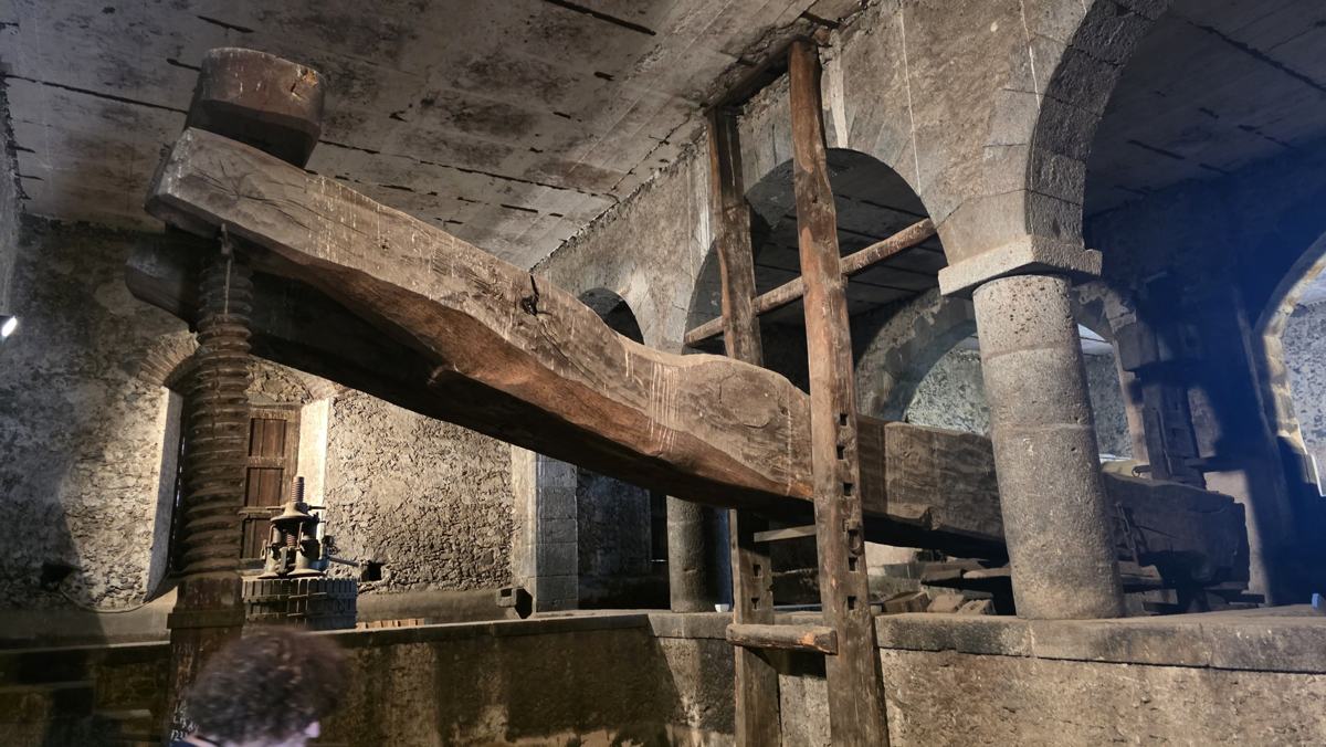 The large wooden press inside the historic winemaking space.