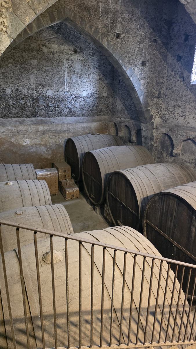 Barrels beneath the stone arches.