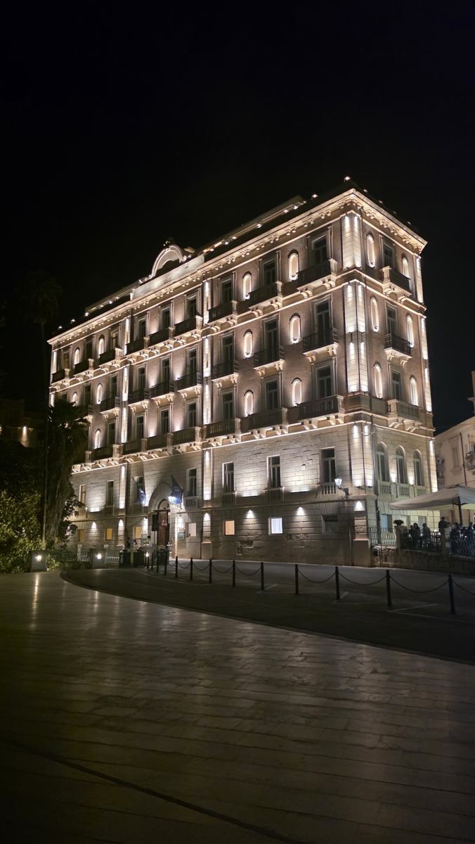 Ortigia’s waterfront buildings illuminated after dark.